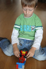 Berlin  Junge spielt mit seinem Legoauto