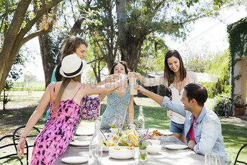 Friends celebrating together with meal outdoors