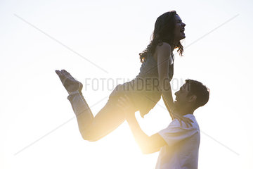 Man lifting wife into air