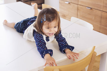 Little girl lying on top of table