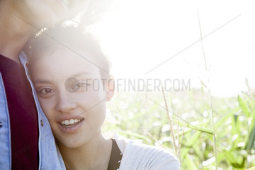 Young woman resting head against boyfriend's chest