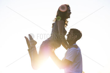 Man lifting girlfriend into air