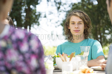 Young man having outdoor meal with friends
