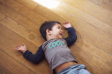 Little boy lying on floor laughing