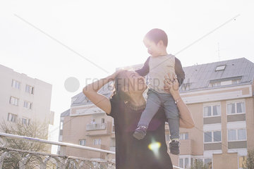 Mother carrying little boy on shoulder
