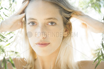 Woman with hands on head outdoors  portrait