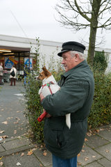 Bremen  Deutschland  Rentner mit Hund wartet vor einem Supermarkt