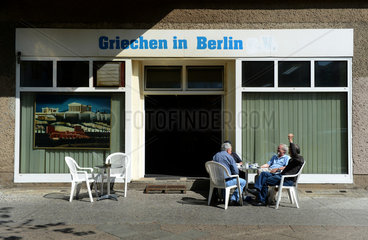 Berlin  Deutschland  Maenner sitzen vor dem Cafe: Griechen in Berlin