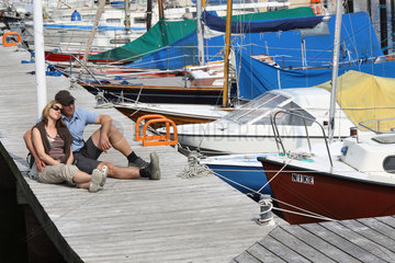 Kiel  Paar sitzt auf einem Bootssteg im Hafen