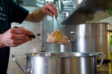 Berlin  Deutschland  Sternekoch Marco Mueller beim kochen von Eisbein