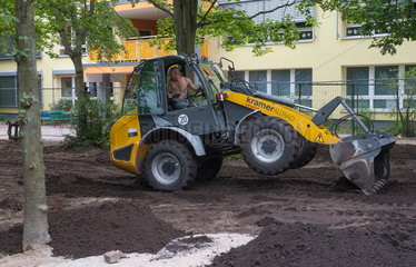 Berlin  Deutschland  ein Radlader planiert den Garten einer Kita