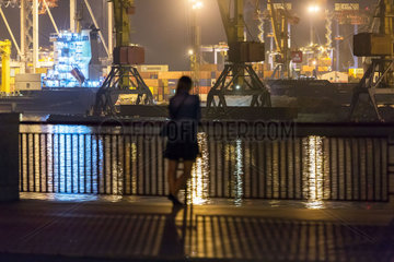 Odessa  Ukraine  eine Frau schaut auf den Containerterminal im Hafen