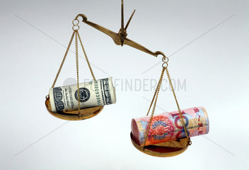 Berlin  Deutschland  Symbolfoto schwacher Dollar. Waage mit Renminbi-Yuan- und Dollarscheinen im Ungleichgewicht
