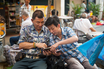 Republik Singapur  Maenner mit Smartphones in Chinatown