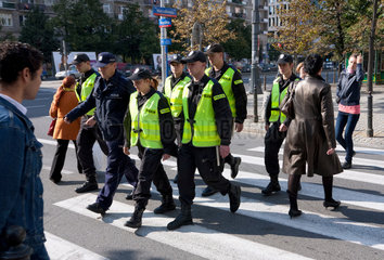 Warschau  Polen  junge Polizisten ueberqueren mit ihrem Vorgesetzen einen Zebrastreifen