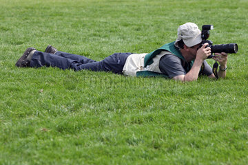 Epsom  Grossbritannien  Mann liegt zum Fotografieren im Gras