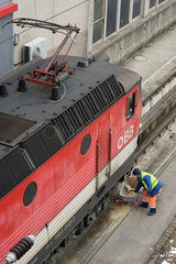 Wien  Oesterreich  Mitarbeiter der OEBB streut Sand vor einer Lok auf die Gleise