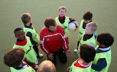 Berlin  Deutschland  Jungen und Trainer bei einer Besprechung beim Fussballtraining