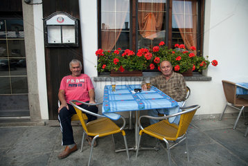 Puschlav  Schweiz  Maenner in einem Strassencafe