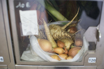 Food locker containing parsnips and shallots in self-serve grocery