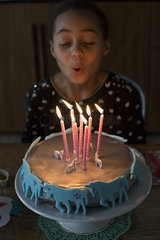 Girl blowing out candles on birthday cake