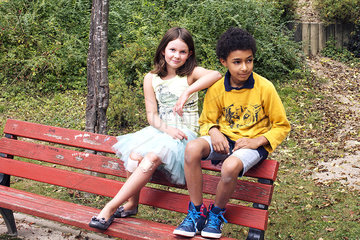 Girl and boy hanging out together on park bench