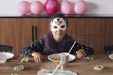 Girl wearing festive mask at birthday party