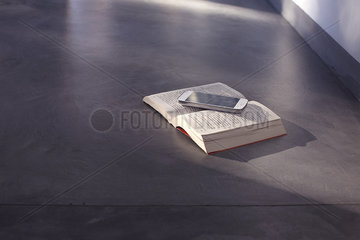 Smartphone resting on open book