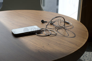Smartphone and earbuds on table