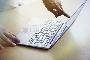 Salesperson showing laptop computer to shopper