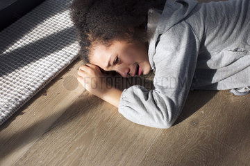 Girl lying on floor crying