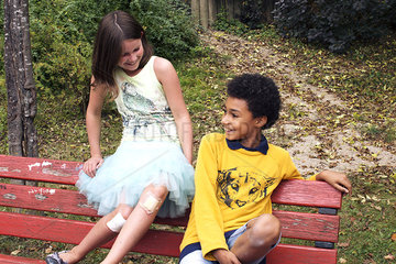 Young friends hanging out together on park bench