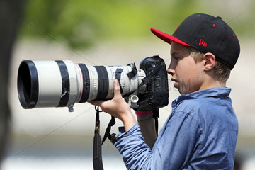 Hoppegarten  Deutschland  Junge fotografiert mit einem Teleobjektiv