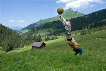 Blatti Alm  Schweiz  ein Junge spielt Ball