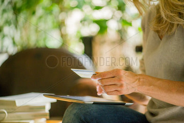 Woman using digital tablet and credit card  cropped