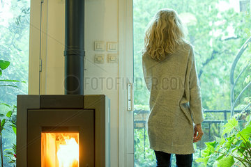 Woman standing in living room  looking out window