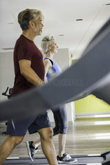 Man and woman exercising on treadmills