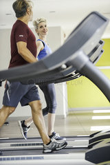 Man and woman exercising on treadmills
