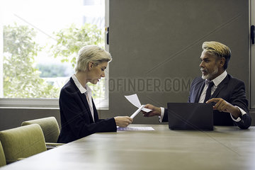 Woman and man in office reading document