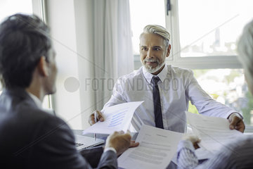 Businessman handing documents to clients