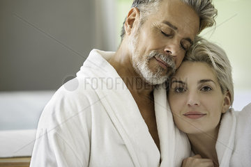 Couple in bathrobes embracing
