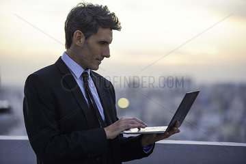Businessman on rooftop using laptop