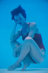 Woman soaking underwater with sad expression