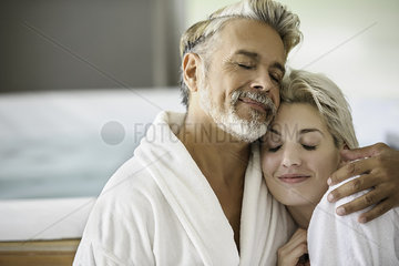 Couple in bathrobes embracing