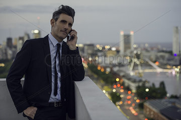 Businessman talking on mobile phone outdoors
