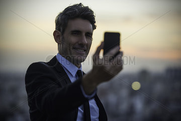 Businessman taking selfie with mobile phone