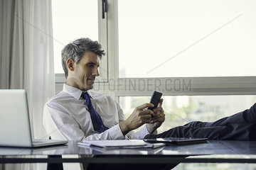Man using smart phone in office