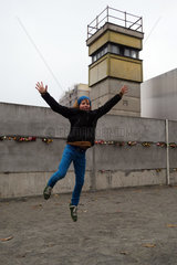 Berlin  Deutschland  Junge macht an der Gedenkstaette Berliner Mauer eine Luftsprung