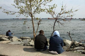 Istanbul  Tuerkei  Menschen sitzen am Ufer zum Marmarameer