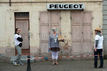 Frankreich - Strassenszene mit verkleidetem Mann und Peugeot-Schriftzug